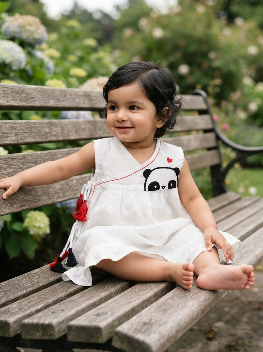 Child in white cotton top against flowers